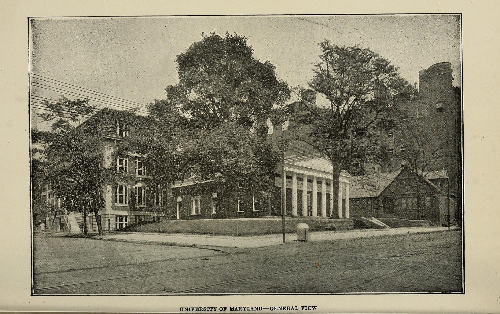 Photograph of UMB Campus circa 1920, has two trees and three buildings.