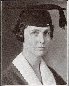 Black and white photograph of a woman with a graduation cap and tassle.