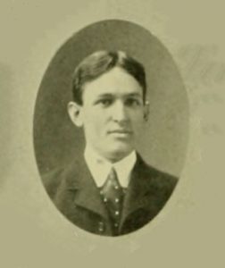 Black and white yearbook photograph of man in jacket.