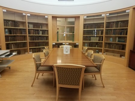 Photograph of a room in the HSHSL Historical Collections, in center of room is a conference table with eight chairs around it, around the room is built in book shelves.