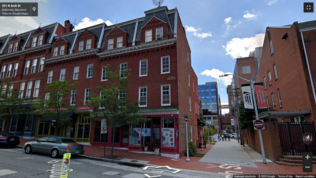 Photograph of a block of brick three story buildings and a walkway