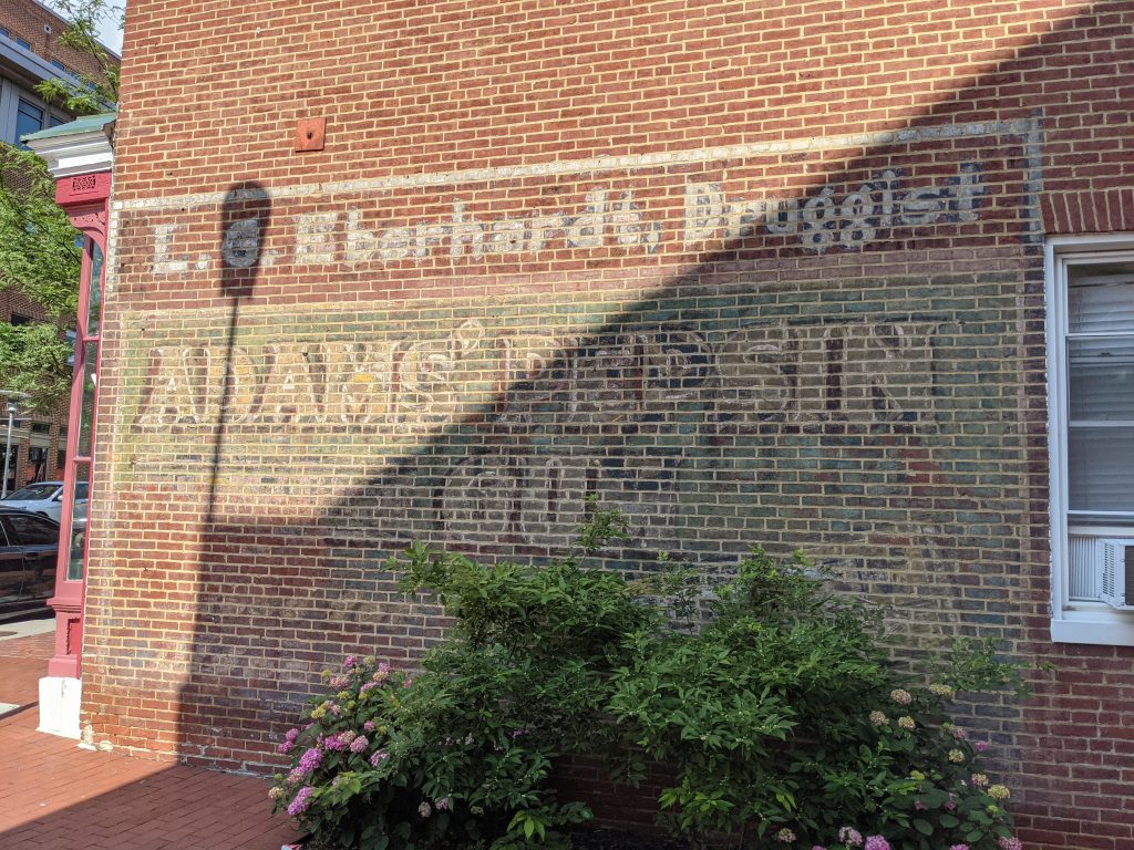 Color Photograph of a brick wall with L.G. Eberhardt, Druggist, Adam's Pepsin Gum advertised