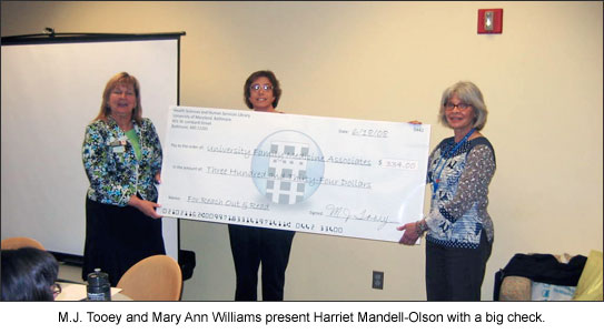 M.J. Tooey and Mary Ann Williams present Harriet Mandell-Olson with a big check.