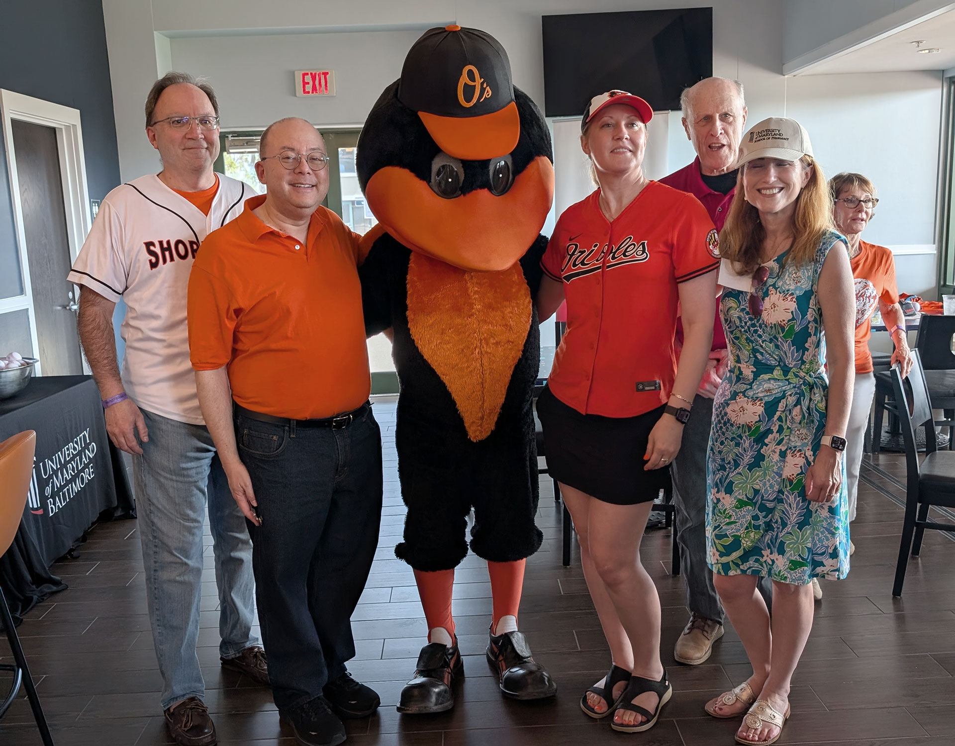 Dean Hurst poses with Greg Bowden, UMB vice president and chief philanthropy officer; Kenneth Wong, PhD, dean of the School of Graduate Studies; Bruce Jarrell, MD, FACS, UMB president; and Sarah Michele, PhD, dean of the School of Pharmacy; and the Oriole Bird at the annual alumni event at the Orioles Spring Training in Sarasota, Florida.