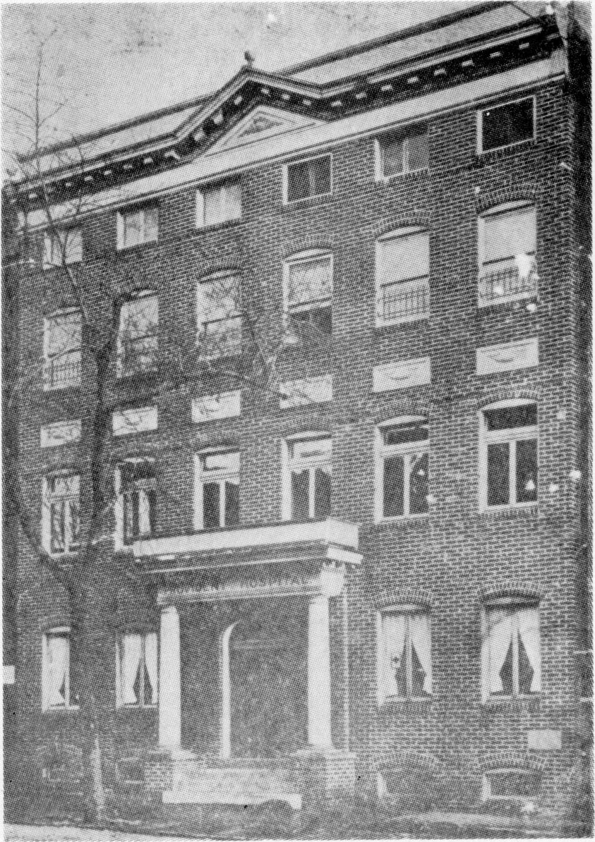 Black and white photograph of a 4 story brick building.