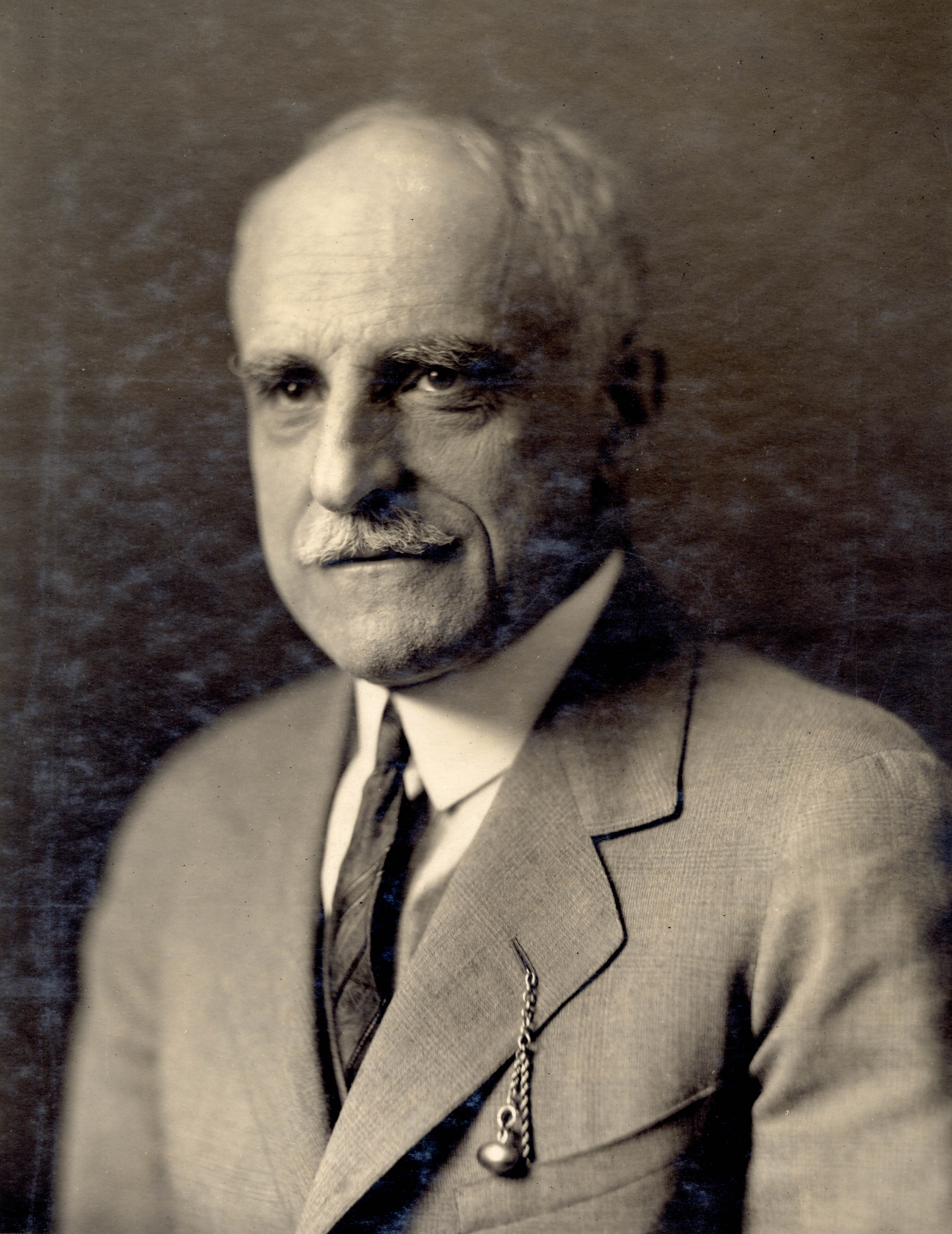 Portrait of Dr. A.W. Valentine in suit jacket and tie. The man appears to be in his 60s, with a mustach and receeding hair. T