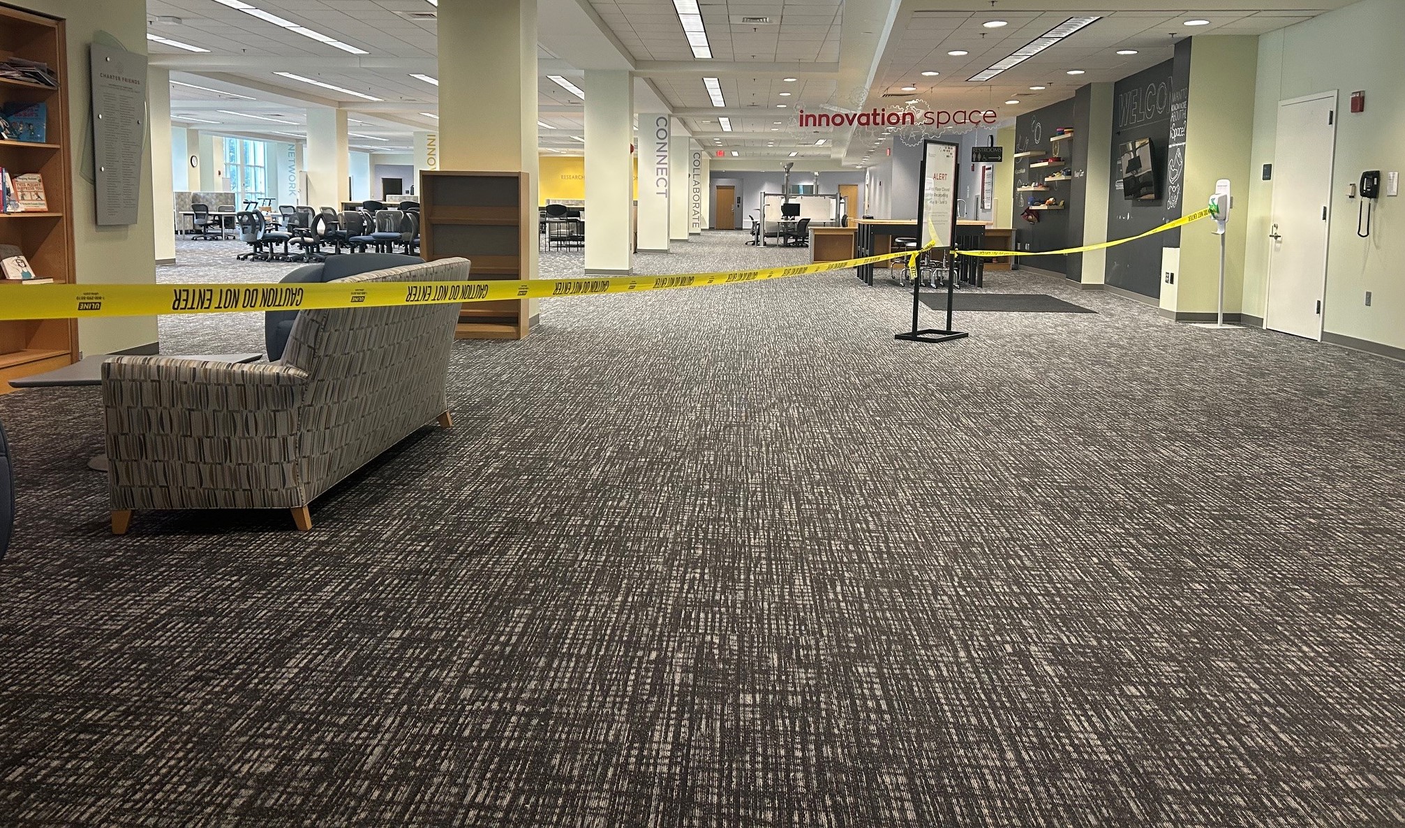 A view of the HSHSL's first floor with new carpeting. Caution tape extends across the floor as the project is ongoing.