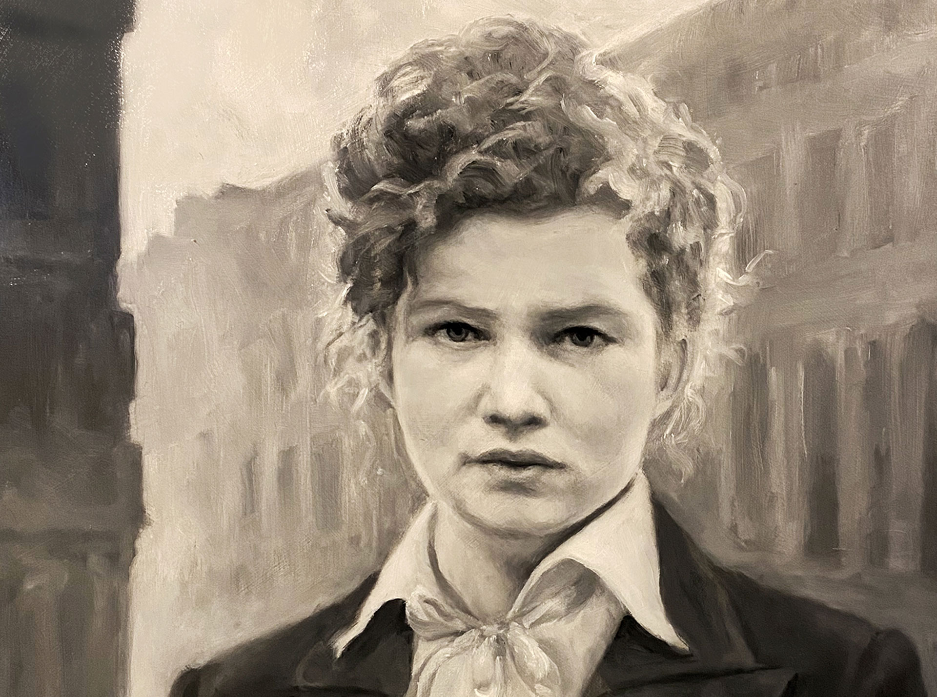 Grayscale portrait of a person with curly hair, wearing a jacket and white collared shirt.
